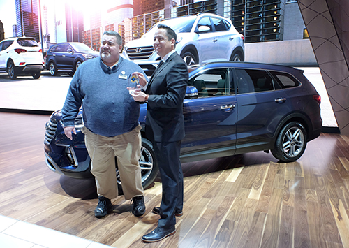 Left to Right: Tom Appel, publisher, Consumer Guide Automotive, presents Brandon Ramirez, senior group manager, product planning, Hyundai Motor America, the trophy for the 2016 Hyundai Genesis and Santa Fe/Santa Fe Sport as the “Best Buy” in their segments at the 2016 Chicago Auto Show.