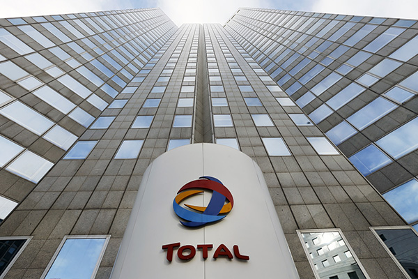 The logo of the French oil giant Total SA is seen at the entrance of the company headquarters in the La Defense business district, west of Paris, Tuesday Feb 5, 2013. (AP Photo/Jacques Brinon)